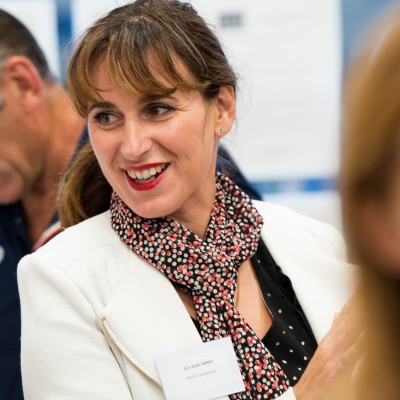 Femme souriante portant un badge nominatif lors d'un événement professionnel